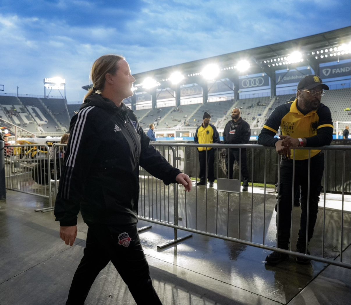 Coach walking on the sidelines of a professional soccer stadium